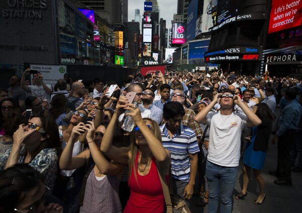 FILE - A crowd reacts to the view of a partial solar eclipse as it peaks at over 70% percent coverage on Monday, Aug. 21, 2017, in New York. (AP Photo/Michael Noble Jr.)